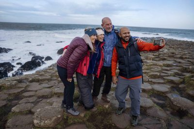 Giants Causeway Courtesy of Tourism Northern Ireland  four people standing on rocky landscape while taking photo