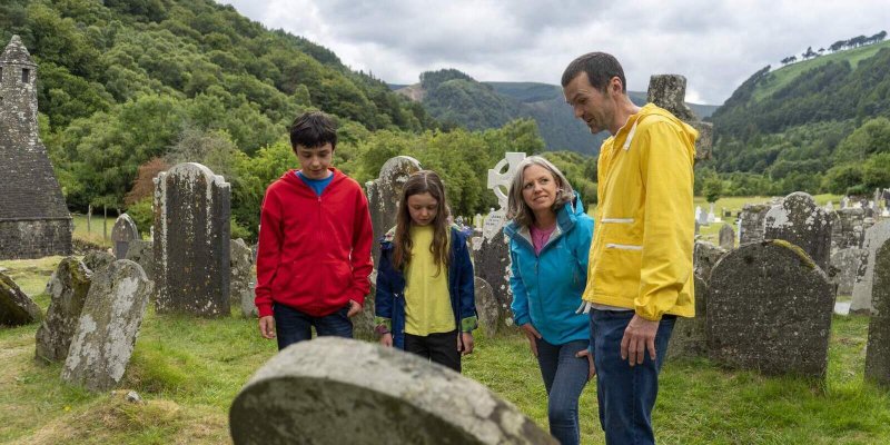 Glendalough Monastic City Courtesy Failte Ireland  family looking at gravestone