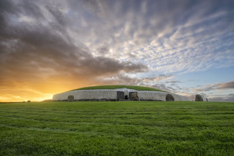 Newgrange Monument  Image of a Stone Age Tomb surrounded by green grass