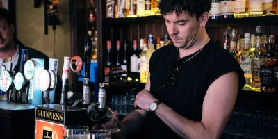 Original Dublin Pub tour 3 male bartender wearing black pouring a pint behind the bar