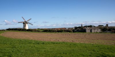 skerries-mills-700 Blue bright skies with Wind mills in the left background. Greenery and hay in the foreground