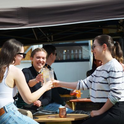 Stillgarden Distillery - Gin Tasting three women sitting and clinking glasses
