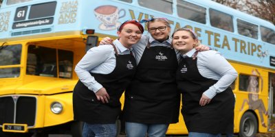 Employee Bus 3 colleagues posing infront of blue and yellow bus