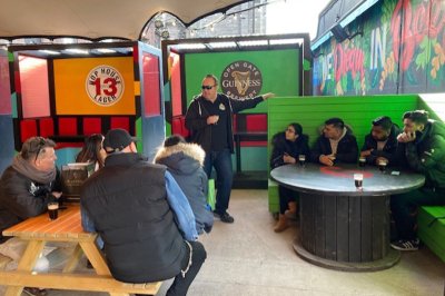 Drinks on Foot Tour - Walking Food Tours  people gathered in a pub with a man standing